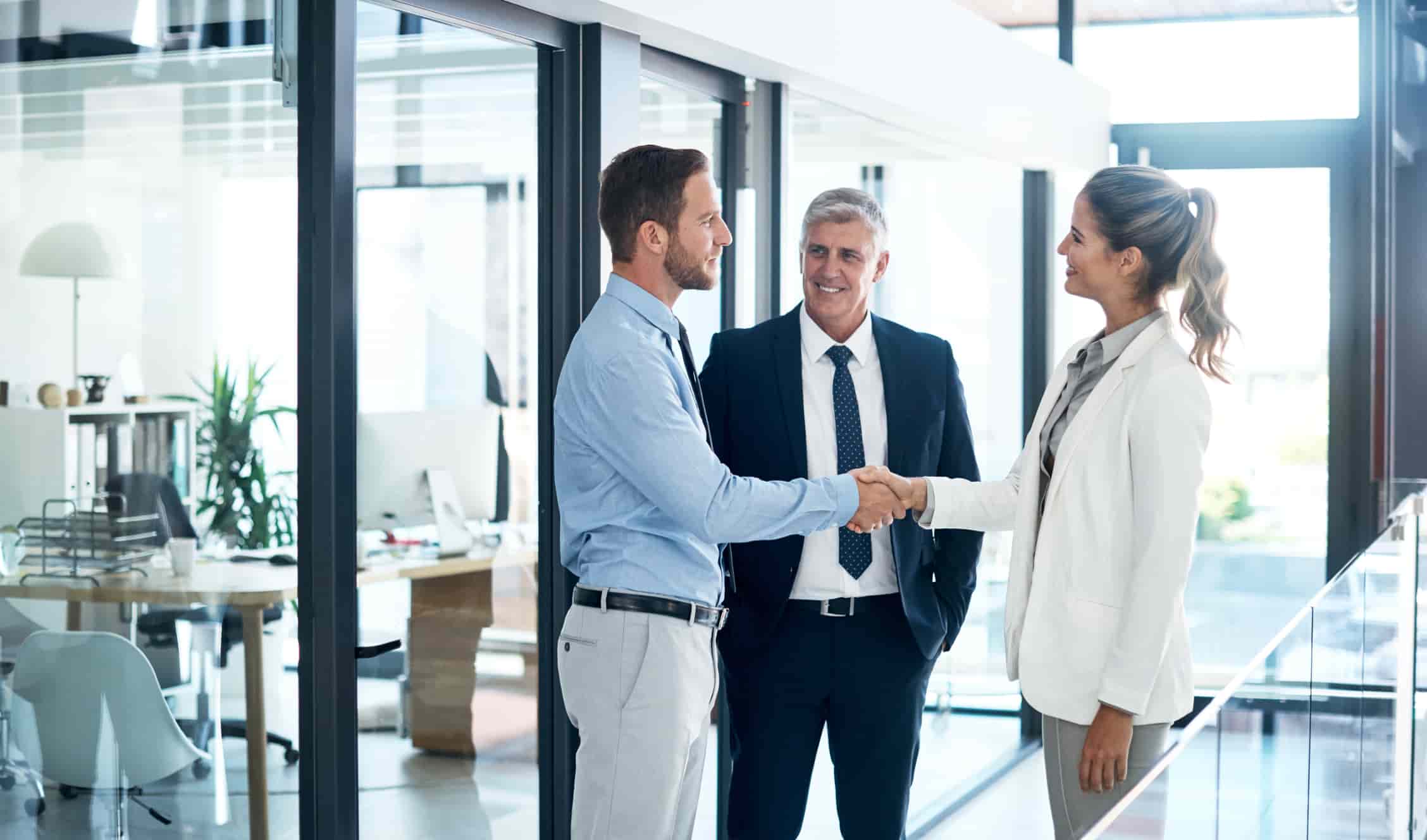 businessman and businesswoman shaking hands in a modern office
